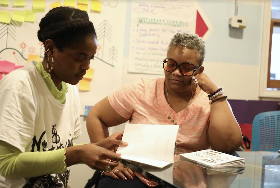 Neta Bomani and Tawana Petty looking at papers